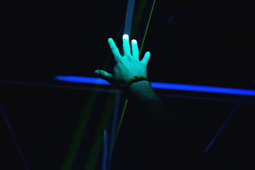 man's hand is raised up in a nightclub on a dark background