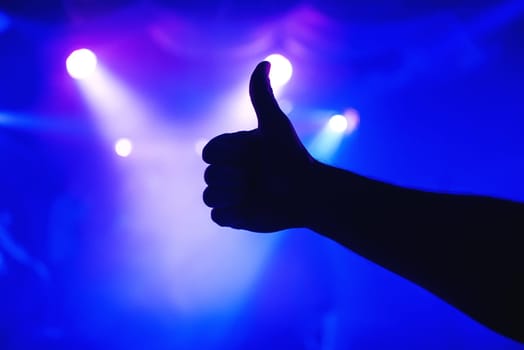 man's hand shows gesture thumbs up on a blurry background