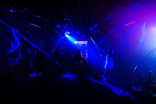 blurred silhouettes of dancing people at a nightclub party