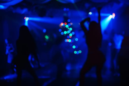 blurred silhouettes of dancing people at a nightclub party