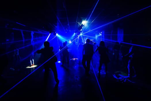 silhouettes of people with the laser light in a nightclub