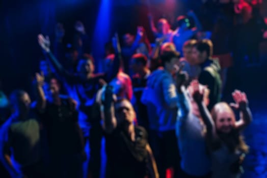 blurred silhouettes dancing merry men at the concert with your hands and joyful