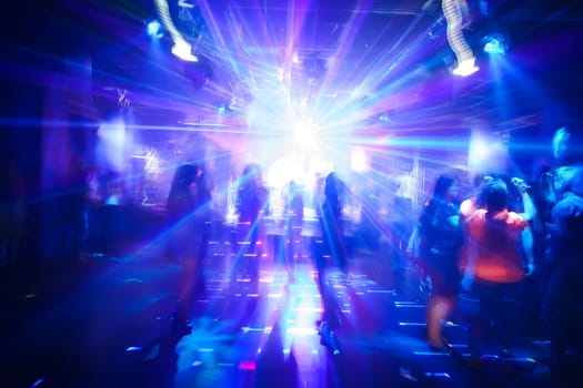 blurred silhouettes of dancing people at a nightclub party