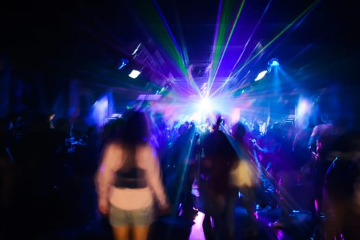 blurred silhouettes of dancing people at a nightclub party