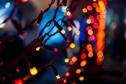 Christmas garland with red and orange lights shining with blurred bokeh