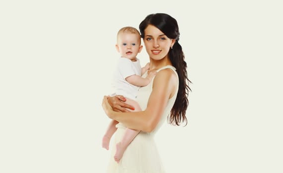 Portrait of happy young mother holding baby on white studio background