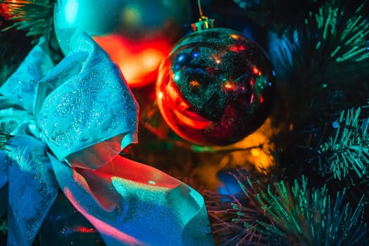 branches of the Christmas tree with pretty ball and bowknot with colorful lighting