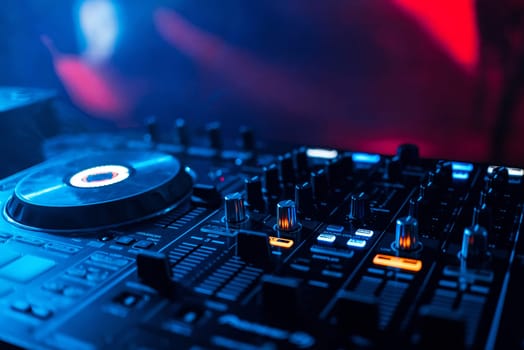 mixer DJ to play at a party in a nightclub for discs and playing music from levels and volume closeup with blurred background