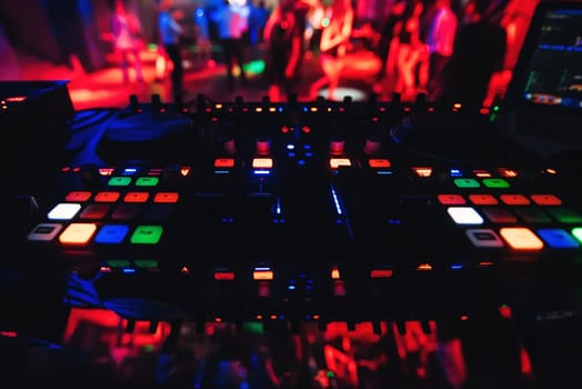 musical panel Board and a DJ for music DJ in a nightclub dancing with blurred people in the background