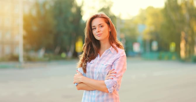 Portrait of beautiful happy smiling brunette young woman posing in the city