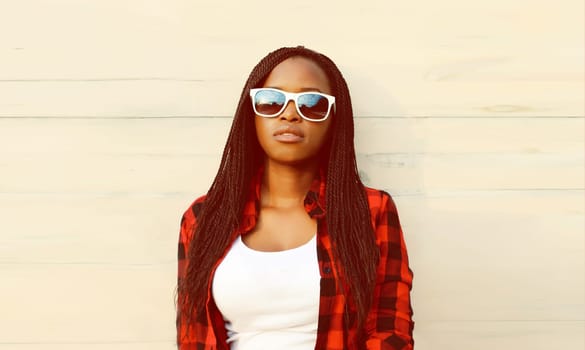 Portrait of stylish young african woman posing wearing casual clothes, sunglasses on white background