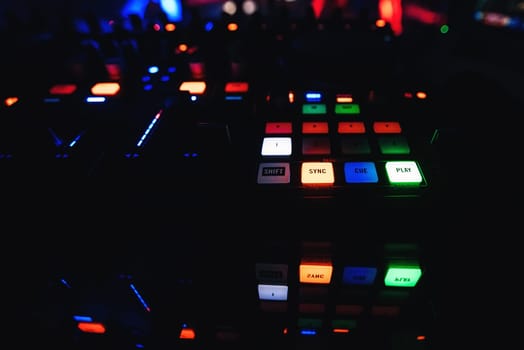 buttons on the mixer DJ with lighting for creating and mixing music with a dark colored background