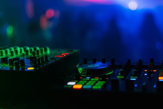 control panel and mixer DJ party night club under colorful lights