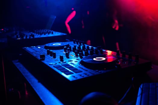 music mixer controller music control DJ under the light of spotlights in the booth at a nightclub
