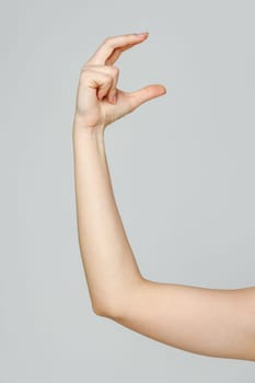 Young Woman Arm with Gesture close up on gray background