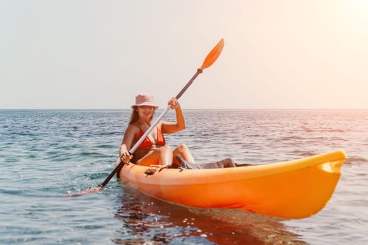 Happy smiling woman in kayak on ocean, paddling with wooden oar. Calm sea water and horizon in background