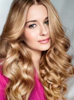 Beautiful blonde woman with curly volume hairstyle, long luxurious hair and beauty makeup, glamorous look face portrait for luxury fashion and natural cosmetics idea