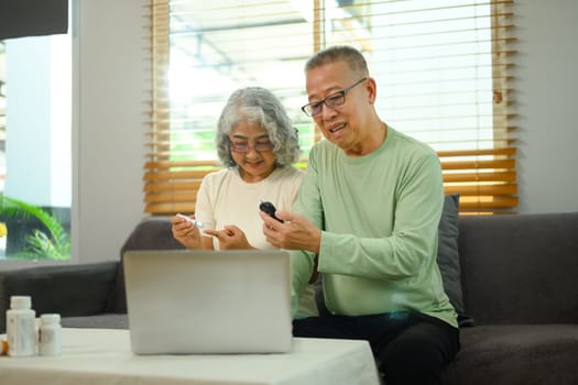 Older couple having a virtual appointment with doctor online via laptop. Telehealth concept.