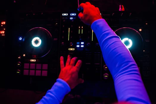 DJ plays music at a professional mixer music at a party the view from the top with a dark light