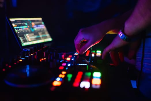hands of a professional DJ playing and mixing music for a slumber party and the torque controllers of the console