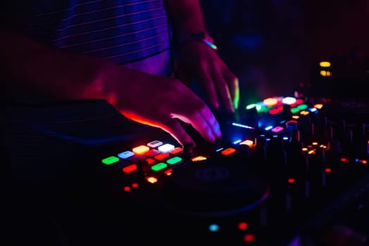hands of modern DJ professional mixer and music Board of the controlling buttons and levels club music