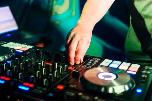 professional music equipment for mixing music in a nightclub with a hand of DJ