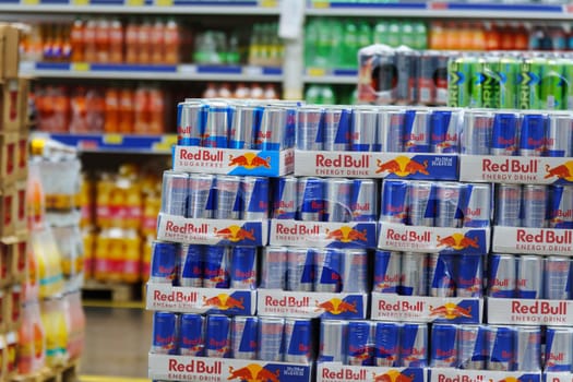 Tyumen, Russia-March 02, 2024: Display in a store is overflowing with cans of Red Bull energy drink, neatly stacked and organized to attract customers.