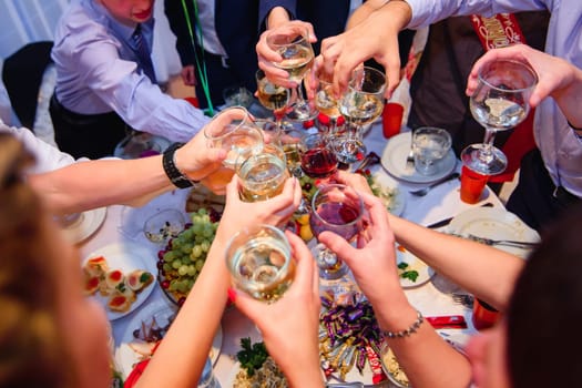 hands with glasses wine clink at a celebration in a restaurant