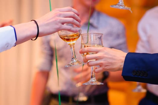 hands with glasses wine clink at a celebration in a restaurant
