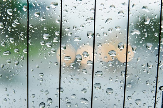 raindrops on the surface of the car glass in rainy weather with a blurred background on the street