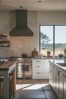 This kitchen features white cabinetry, stainless steel appliances, a gas stove, and a large window for natural lighting, creating a modern and sleek interior design