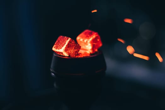 hot red coals for hookah with sparks on dark background close up