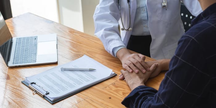 Close-up view of a female doctor giving advice and encouragement to a stressed young patient with health and medical problems in the clinic.