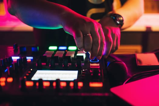hands of a DJ playing at a professional mixer in nightclub closeup