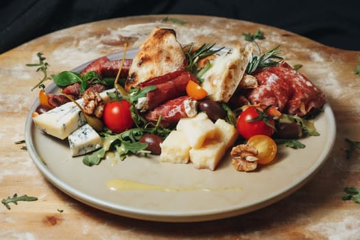 A plate brimming with a variety of meats and colorful vegetables resting atop a wooden board.