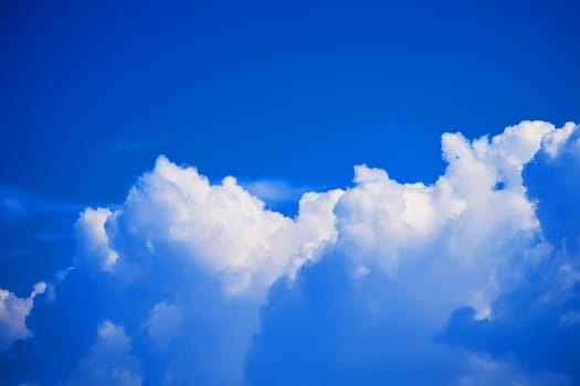 background of blue sky with white fluffy clouds on a clear Sunny day