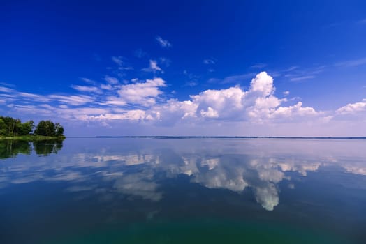 clean blue sky reflected in calm water on a summer day