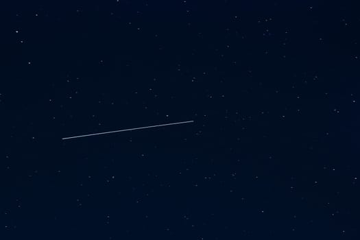 shooting star against a dark blue starry night sky