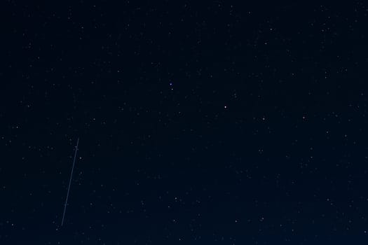 night sky with shimmering coloured stars with the shooting star