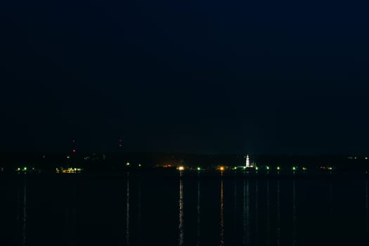 night city with the Church of the dark night reflected in the water of the river