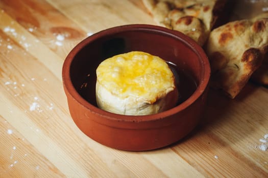 A bowl of delicious cheese elegantly placed on a rustic wooden table, ready to be served and enjoyed.