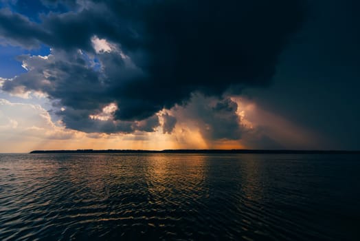 dramatic sky with clouds and sun rays over the river in summer cloudy