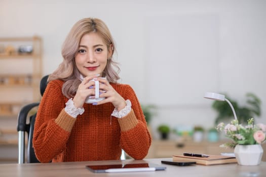 Beautiful young woman drinks coffee and tea in the morning Sit back and relax in the living room..