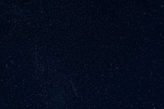 shooting stars against the starry blue of the night sky with the milky way