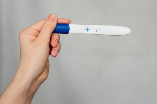 positive pregnancy test in the hands of a girl close-up