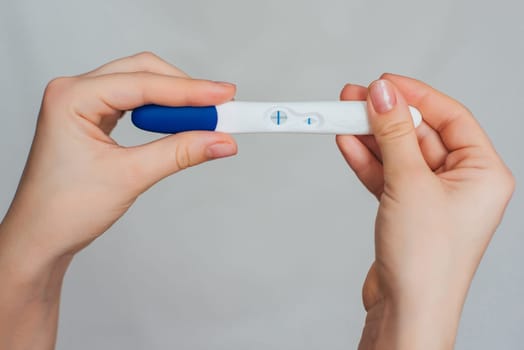 pregnancy test in the hands of a girl with a positive result close up