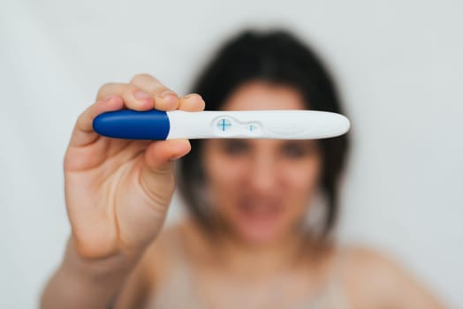 positive pregnancy test in hands of happy girl close up