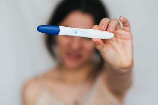 positive pregnancy test in hands of happy pregnant girl close up