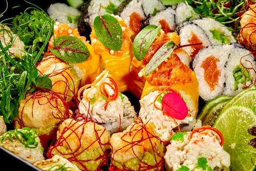 Enticing sushi rolls with topping of salmon, seafood and vegetables garnished with lime slices, chili strands, fresh greens and flower petals. Blend of traditional Japanese flavors with modern twist