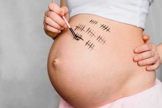 pregnant girl draws on her belly pregnancy term close-up